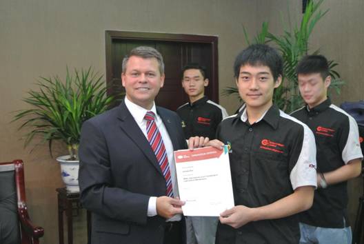 Andrew Moore, managing director of Emtec Colleges Limited, grants IMI certificates to students at Chengdu Industrial Vocational Technical College. Photo provided to China Daily