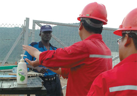 Workers disinfect their hands at a Sinopec oil drilling operation in Uganda to prevent the danger of infection. Provided to China Daily