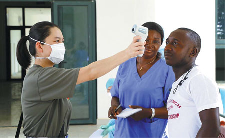 A Chinese medical worker demonstrates equipment to test body temperature at the China-Sierra Leone Friendship Hospital in Freetown. Huang Xianbin / Xinhua