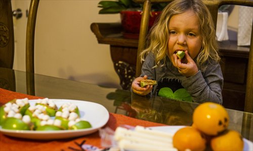 3-year-old Liam McManus samples one of the scary treats his mother has prepared. Photo: Li Hao/GT