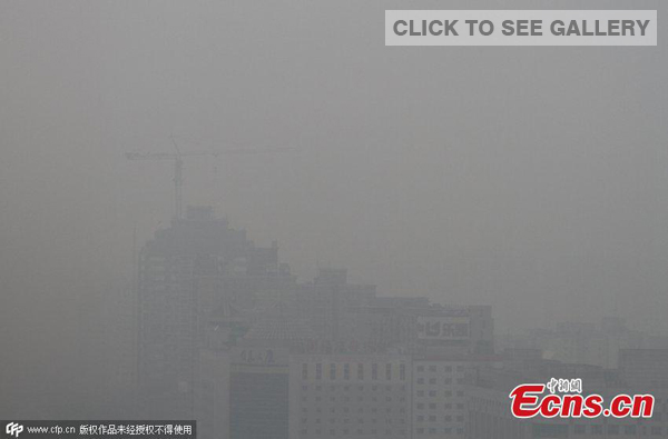 Photo taken on October 8, 2014 shows buildings in the Xicheng district of Beijing. Environmental authorities of the city issued a yellow smog alert at 9 am. It is the first time the city has issued a yellow alert for pollution in the second half of this year. [Photo/ CFP]