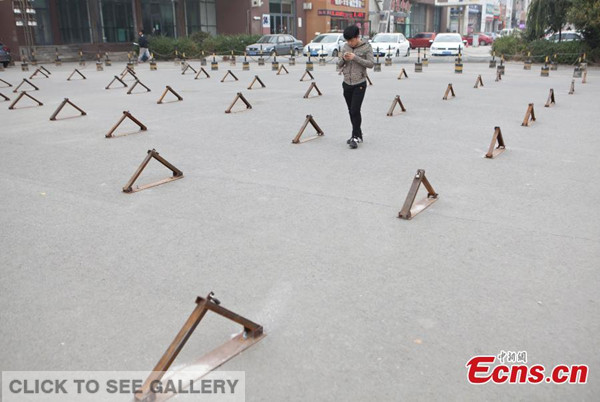 Several parking locks are seen installed on a small square of a residential community in Changchun, Jilin province on October 9, 2014. These locks were installed by property management office of the community to deter people from dancing on the square. [Photo: China News Service/ Zhang Yao]