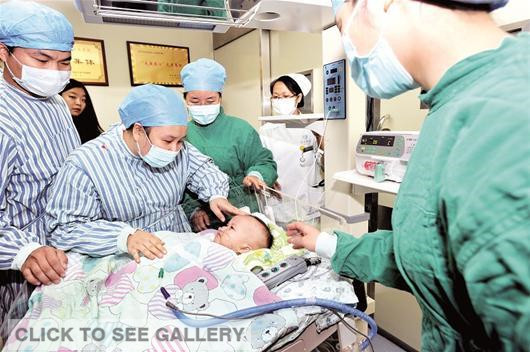 Medical staffs of a hospital in Wuhan of Hubei province check on the status of a baby boy, the country's youngest ever recipient of a heart transplant, on Oct 14, 2014. [Photo: cnhubei.com] 
