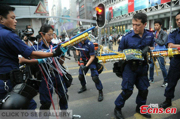 Hong Kong police remove blockades erected by Occupy Central students at a protest site in the bustling area of Mong Kok, Hong Kong on October 17, 2014. [Photo: China News Service/ Tan Daming] 