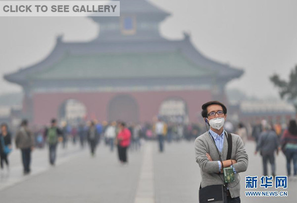 Photo taken on Oct 19, 2014 shows a visitor to Temple of Heaven, Beijing, wearing a face mask. The heavy smog that has shrouded some regions of north China since Saturday will ease on Monday thanks to a cold front, according to a forecast by the national observatory on Sunday. (Xinhua photo)
