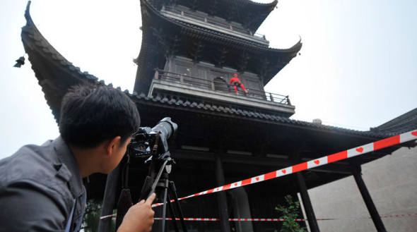 A Santa Clause climbs down from a 51-meter high building in Wuzhen during the Wuzhen Theatre Festival. (Photo/Screenshot from CNTV)