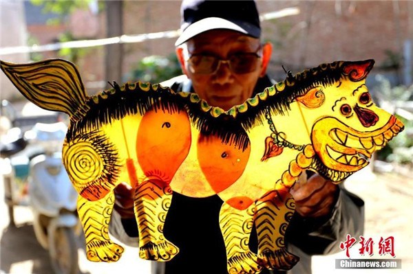 Lv Xinzhe with a puppet in Lvzhuang village, Henan province, Nov 2, 2014. [Photo/Chinanews.com]