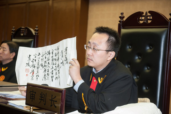 A judge in a court in Beijing displays an original copy of a will during a case about disputed inheritance. An increasing number of elderly people in the capital are turning to professional organizations or law firms for help in dealing with their property after they die. PU DONG FENG / FOR CHINA DAILY 
