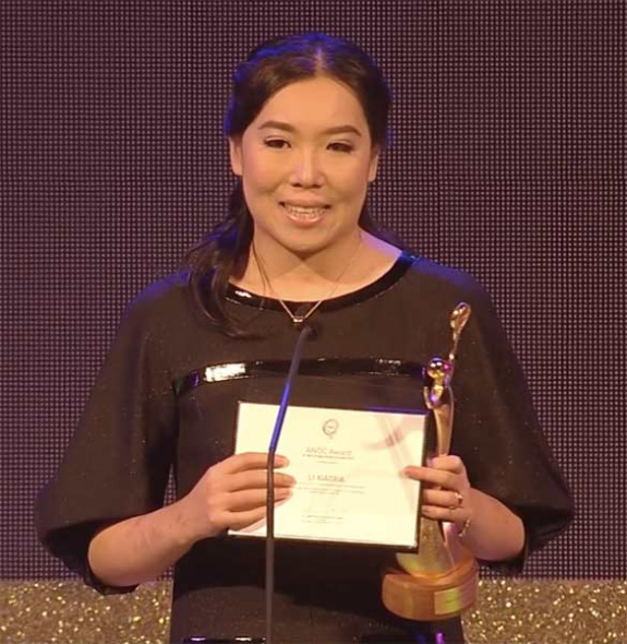 A still image grab from the video provided by ANOC shows Li Xiaoxia making a speech afrer receiving the trophy from the Vice-President of ANOC for Oceania Robin Mitchell, in Bangkok, Thailand, on Nov 7, 2014. [Photo/chinadaily.com.cn]