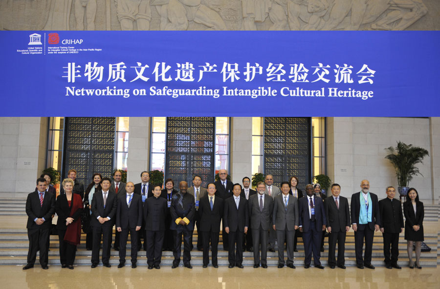 Chinese and international participants pose for a photo during a networking meeting on intangible cultural heritage protection in Beijing, Nov 7, 2014. [Photo provided to chinadaily.com.cn]  