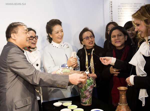 Angelica Rivera Hurtado (R), wife of Mexican President Enrique Pena Nieto, tries drawing on a Chinese cloisonne-enameled vase as she and the wives of some other leaders and representatives from the Asia-Pacific Economic Cooperation (APEC) member economies visit a cloisonne ware studio in the Summer Palace at the invitation of Peng Liyuan (3rd L), wife of Chinese President Xi Jinping, in Beijing, China, Nov. 11, 2014. (Xinhua/Huang Jingwen)