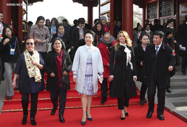 Peng Liyuan (C), wife of Chinese President Xi Jinping, accompanies the wives of some leaders and representatives from the Asia-Pacific Economic Cooperation (APEC) member economies during a visit to the Summer Palace in Beijing, China, Nov. 11, 2014. (Xinhua/Ding Lin)