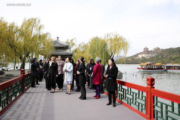Peng Liyuan (C), wife of Chinese President Xi Jinping, accompanies the wives of some leaders and representatives from the Asia-Pacific Economic Cooperation (APEC) member economies during their visit to the Summer Palace in Beijing, China, Nov. 11, 2014. (Xinhua/Ding Lin)