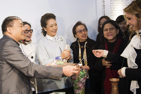First lady Peng Liyuan helps her Mexican counterpart, Angelica Rivera, put the final touches on a traditional Chinese cloisonne vase during a tour of the Summer Palace in Beijing on Tuesday.[Photo/Xinhua]