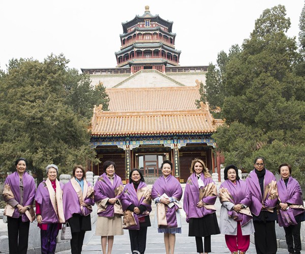 Peng, fifth right, and her guests pose for a group photo in front of the main buildings of the Summer Palace at the foot of Wanshou Mountain.[Photo/Xinhua]  