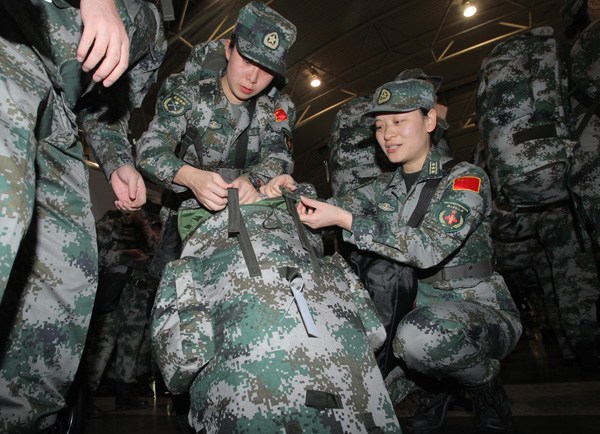 Members of a PLA medical team pack their supplies in Beijing on Friday before setting off for West Africa. More than 200 medical workers and experts will help Liberia and Sierra Leone combat the Ebola virus, which has caused more than 5,000 deaths. WANG JING/CHINA DAILY   
