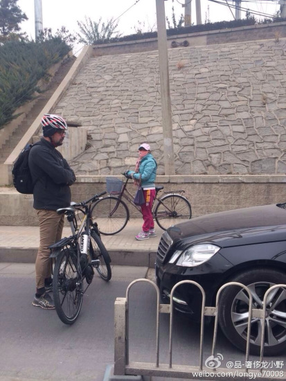 The photo taken on November 15, 2014 shows a foreign man blocked a Mercedes Benz sedan, with his bicycle in between, at the end of an isolated bike lane on eastern Beijing's Yaojiayuan Road. [Photo: weibo.com/longye70008]