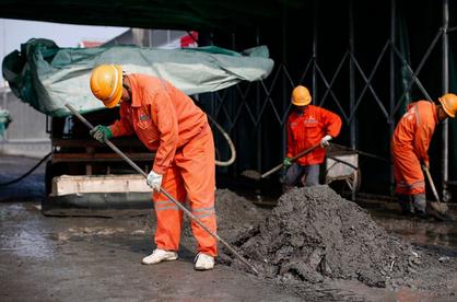 Workers prepare fast-setting concrete being used with the water knife cutting machine at a construction site on Tongji Elevated Road in Baoshan District yesterday.  Yang Yi