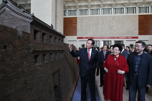 Chen Yunlin (left), former president of the Association for Relations Across the Taiwan Straits; Chen Lihua (center), founder of the Red Sandalwood Museum of China in Beijing; and Zheng Xinmiao (right), former director of the Palace Museum, look at a model of Yongdingmen Gate made of sandalwood at the National Museum of China in October 2013. Photo provided to China Daily