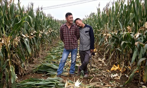 Anwei (left) and Yebin stand in the cornfields in front of their house after a day's harvesting. Photo: Feng Zhonghao