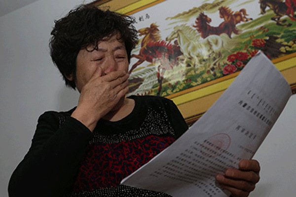 Shang Aiyuan bursts into tears upon receiving the decision of the court to rehear her executed son's murder case at her home in Inner Mongolia autonmous region on Thursday. [Photo/Legal Evening News] 