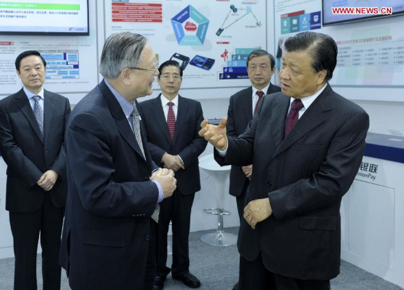 Liu Yunshan (R, front), a member of the Standing Committee of the Political Bureau of the Communist Party of China (CPC) Central Committee and secretary of the Secretariat of the CPC Central Committee, talks with a representative from China UnionPay as he visits an exhibition of network safety after the launching ceremony of the China Cybersecurity Week in Beijing, capital of China, Nov. 24, 2014. (Xinhua/Zhang Duo)