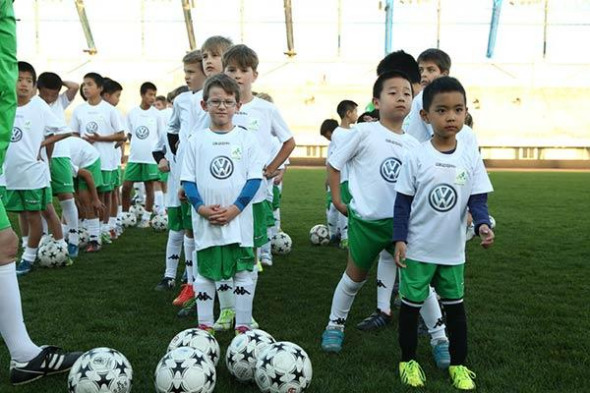 Chinese and international young players stand together during the football training session in Beijing, Oct 15, 2014. [Photo provided to chinadaily.com.cn]