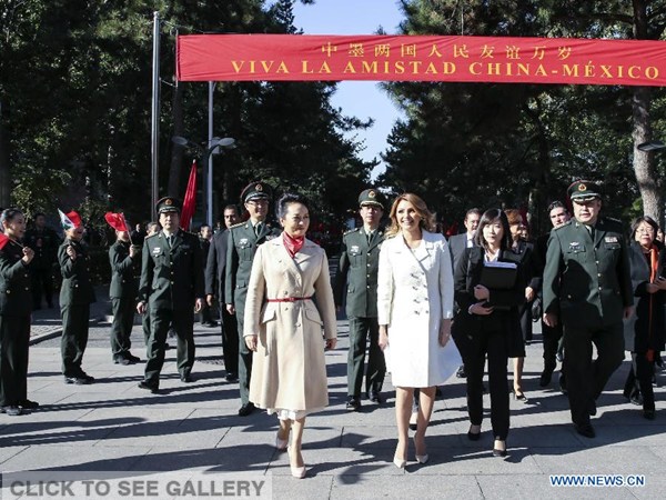 Students wave the national flags of China and Mexico to welcome Angelica Rivera (R, front), wife of Mexican President Enrique Pena Nieto, accompanied by Peng Liyuan (L, front), wife of Chinese President Xi Jinping, at the Academy of Arts of the Chinese People's Liberation Army (PLA) in Beijing, capital of China, Nov 13, 2014. (Xinhua/Lan Hongguang)