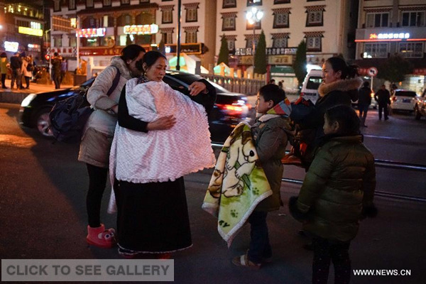 Residents stand on the road to avoid the earthquake in Kangding County, southwest China's Sichuan province, Nov 25, 2014. A 5.8-magnitude earthquake struck Kangding County, Ganzi Tibetan Autonomous Prefecture of southwest China's Sichuan province, at 11:19 pm Tuesday, the China Earthquake Networks Center said. (Xinhua/Li Qiaoqiao) 