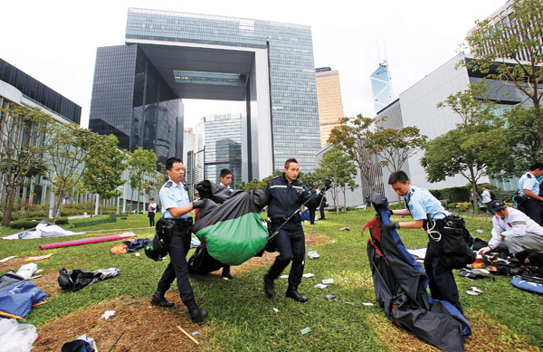 Police remove a tent as they attempt to clear a demonstration site near the chief executive's office in Hong Kong on Monday. EDMOND TANG / CHINA DAILY