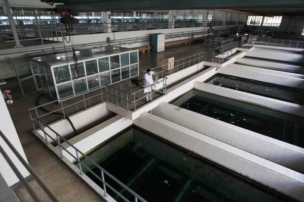 A worker takes samples for testing at a water plant in Beijing. A survey has found that more than 75 percent of Chinese urban residents are willing to pay more for safer water. GAN NAN/CHINA DAILY