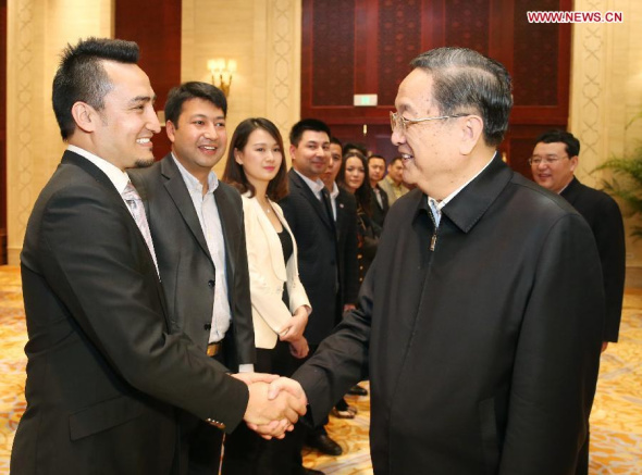 Yu Zhengsheng (R), chairman of the National Committee of the Chinese People's Political Consultative Conference (CPPCC), meets with Kurbanjan Samat (L, front), author of the book I'm from Xinjiang, and some representatives mentioned in his book, in Beijing, capital of China, Dec. 9, 2014. (Xinhua/Yao Dawei)