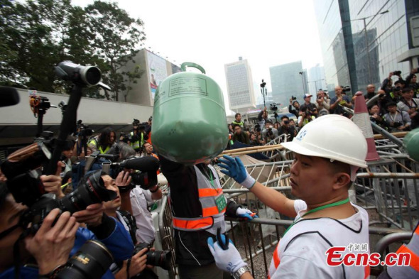 Workers in safety vests and helmets dismantle barricades set up by protestors in an Occupy site in Admiralty of Hong Kong on Thursday, December 11, 2014. [Photo/ China News Service/ Hong Shaokui] 