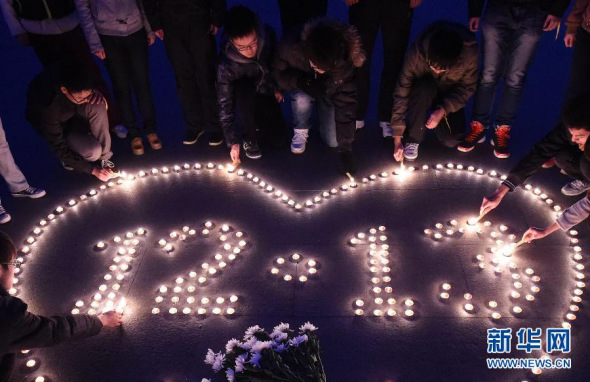 Students in Nanjing, east China's Jiangsu Province, light candles to mourn the victims of the Nanjing Massacre on December 12, 2014. (Xinhua Photo)