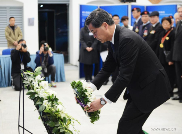 Hong Kong's Chief Executive Leung Chun-ying presents a wreath to mourn victims of the Nanjing Massacre during China's first National Memorial Day for Nanjing Massacre Victims in Hong Kong, south China, Dec 13, 2014. (Xinhua/Liu Yun)