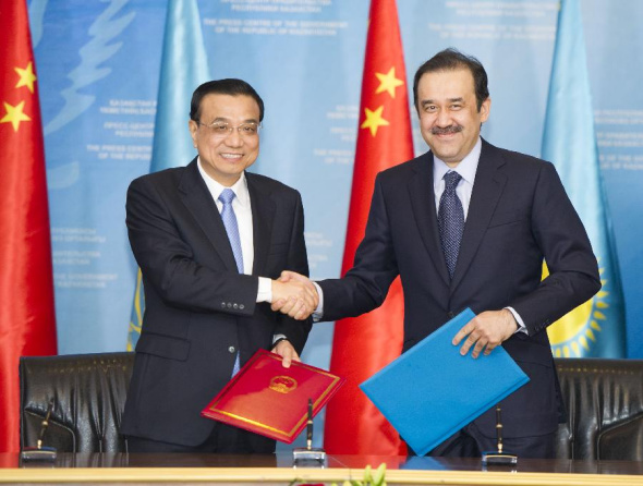 Chinese Premier Li Keqiang (L)and his Kazakh counterpart Karim Masimov attend a signing ceremony of bilateral cooperation documents in Astana, Kazakhstan, Dec. 14, 2014. (Xinhua/Huang Jingwen)