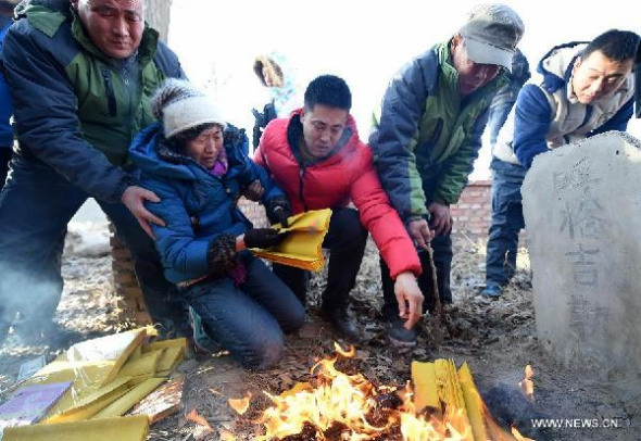 Li Sanren (2nd R) and Shang Aiyun (2nd L), parents of Huugjilt who was executed in a controversial 1996 rape and murder case, mourn their son in front of his grave in Hohhot, capital of north China's Inner Mongolia Autonomous Region, Dec. 15, 2014. 