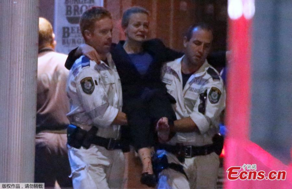 A person is taken out from the Lindt Cafe, Martin Place following a hostage standoff on December 15, 2014 in Sydney, Australia. Police stormed the Sydney cafe as a gunman had been holding hostages. [Photo/Agencies] 