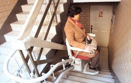 Wang Qian uses the stairlift at her residential building.  Zhang Suoqing