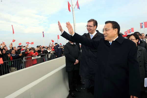 Premier Li Keqiang and his Serbian counterpart Aleksandar Vucic wave to crowds during the inauguration ceremony for the Mihajlo Pupin Bridge in Belgrade on Thursday. The bridge is the first to be built by China in Europe. RAO AIMIN / XINHUA