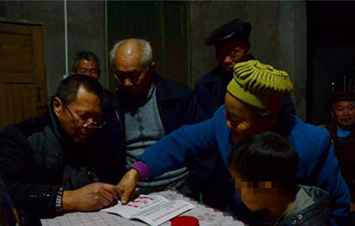 A woman puts her fingerprints on the petition letter with Kunkun standing beside her. [Photo/sc.people.cn] 