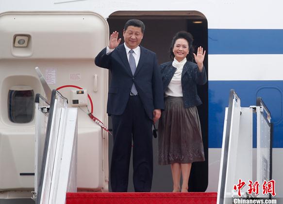 Chinese President (L) Xi Jinping and his wife Peng Liyuan wave as they arrive at the international airport in Macao, south China, Dec. 19, 2014. (Photo: chinanews.com)