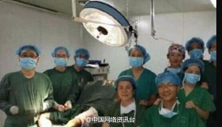 Doctors take group selfies next to a patient inside an operating room in Xi'an Fengcheng Hospital on Aug 15, 2014. [Photo/Sina Weibo]  