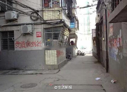 Red graffiti reading AIDS demolition team on the walls of buildings in a residential community in Nanyang of Central China's Henan province. [Photo/shenghuoxinbao]
