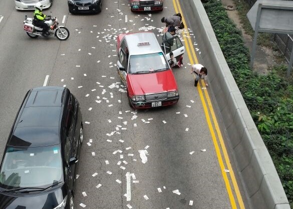 Passers-by grab the cash fallen out of a armor van in Hong Kong on December 24, 2014. [Photo/Sina.com]