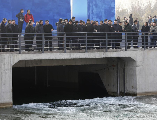 People watch the opening of a sluice gate of the middle route of the south-to-north water diversion project in Beijing, capital of China, Dec 27, 2014. (Xinhua/Yin Gang)