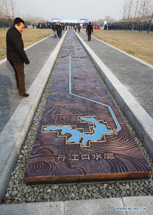 People look at a strip sculpture mapping the middle route of the south-to-north water diversion project, at the opening ceremony of the sluice gate openning in Beijing, capital of China, Dec 27, 2014. (Xinhua/Yin Gang)