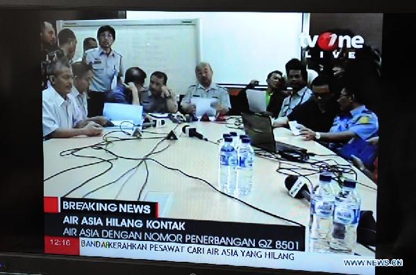Photo taken on Dec 28, 2014 shows local television broadcasting a press conference held at Soekarno-Hatta airport in Jakarta, Indonesia. An Air Asia jetliner lost contact with ground control on Sunday after takeoff from Indonesia on the way to Singapore, and authorities had launched a search and rescue operation. (Xinhua/He Changshan)