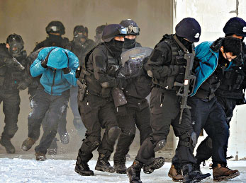 SWAT team members subdue suspected hijackers during a drill in Urumqi, Xinjiang Uygur autonomous region, on Monday. Fang Tao / Xinhua  