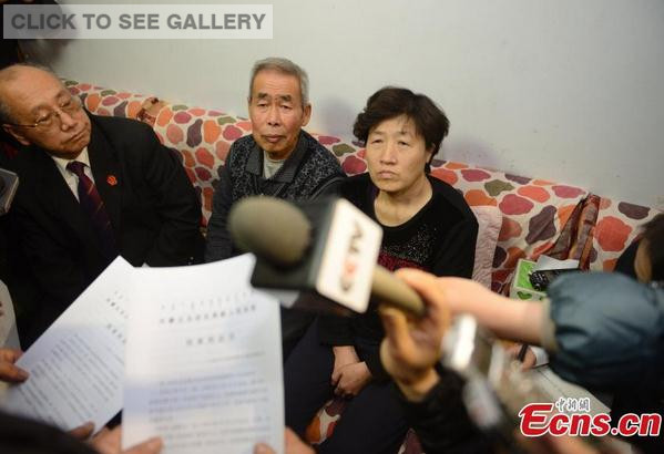 Li Sanren (C) and Shang Aiyun(R), parents of Huugjilt who was executed in a controversial 1996 rape and murder case, receive legal document on retrial in Hohhot, capital of north China's Inner Mongolia Autonomous Region, Dec. 15, 2014. [Photo/ Liu Wenhua] 